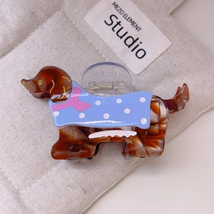 Détail d'une pince à cheveux teckel en acétate écaille avec motif de pull bleu mignon