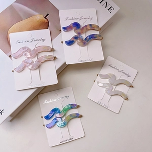 Set of 4 wave-shaped acetate hair clips with marble texture in assorted colors