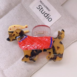 Détail de la texture écaille de tortue ambre sur la pince à cheveux en forme de teckel