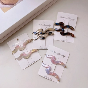 Set of wavy acetate hair clips in tortoiseshell and marble patterns on display cards