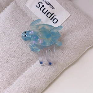 Detail view of turtle hair claw clip made of blue iridescent cellulose acetate