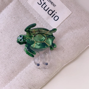 Detailed macro view of sea turtle hair claw clip with green acetate finish and golden lines