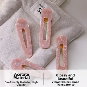 Macro détaillée de quatre barrettes en acétate rose avec des motifs marbrés élégants