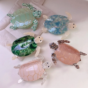 Elegant turtle shaped acetate hair claws in five colors with golden geometric line accents