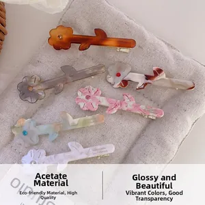 Détail de barrettes à fleurs en acétate avec texture marbrée et strass étincelants