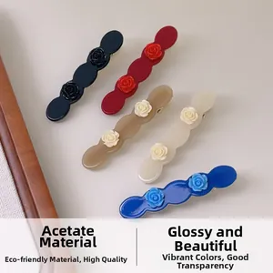 Detail showing five assorted colors of acetate hair clips with 3D rose flower accents