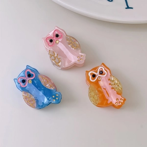 Three-piece set of cute acetate owl hair claws in pink, blue, and orange with gold accents