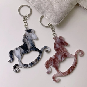 Close-up of rocking horse acrylic keychains with marble patterns and silver clips