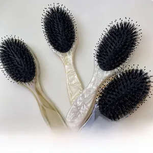 Detail of four acetate cushion hairbrushes with tortoiseshell and marble patterns