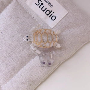 Turtle shaped hair claw clip in pearl white with golden honeycomb patterns and acrylic grip