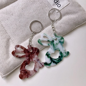 Vue détaillée de porte-clés lapin en acrylique avec motif marbré et découpe de cœur
