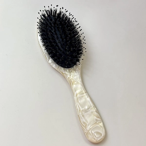 Close-up of marble pattern handle and boar bristle air cushion hairbrush detail