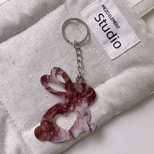 Détail du porte-clés lapin en acrylique avec texture marbre rouge et cœur évidé