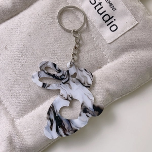Détail d'un joli porte-clés lapin en acrylique avec motif marbre sur sac en toile