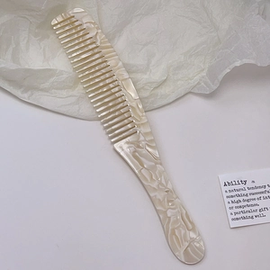 Detail eines Perlmutt-Acetatkamms mit breiten Zinken und elegantem Marmormuster