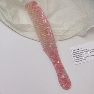 Detailansicht eines rosa Marmor-Acetatskamms mit feinen Zinken und poliertem Finish