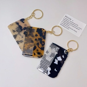 Detailed view of acetate tortoiseshell mini comb keychains with golden metal rings