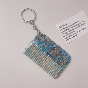 Detail of a blue marble texture acetate comb keychain with a polished silver metal ring