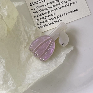 Gros plan d'une pince à cheveux tulipe violette nacrée avec détails en cristal