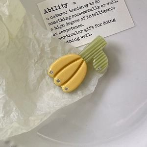 Vue détaillée d'une pince à cheveux tulipe aux pétales jaunes et feuilles vertes