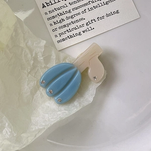 Détail de la pince à cheveux tulipe en acétate avec pétales bleu ciel et strass