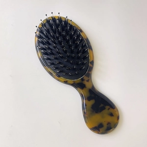 Detailed close-up of tortoise shell pattern handle and mixed bristle cushion hairbrush