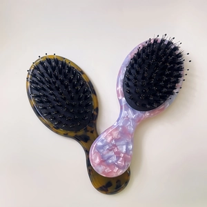 Macro shot of portable acetate hair brushes with tortoise and marble textures