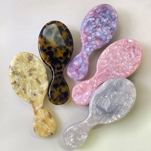 Portable acetate hair brushes with boar bristles in various stylish marble patterns