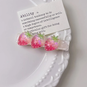 Dettaglio di fermagli per capelli a fragola in resina rosa con base perlata per ragazze
