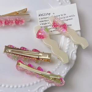 Set di fermagli per capelli a fragola rosa con ciondoli glitterati su piatto decorativo