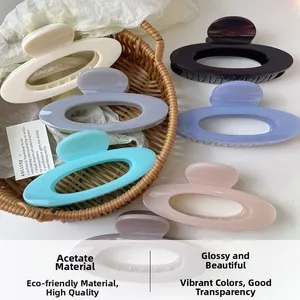 Close-up of acetate hollow oval hair claws in various elegant colors on a woven basket