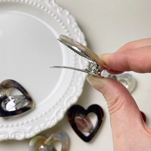 Detail of acetate heart hair clips showing the durable metal duckbill clip mechanism