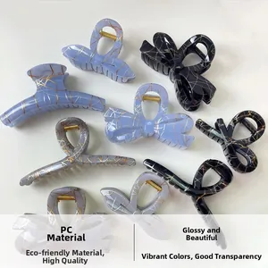 Detail of assorted PC hair claws with lace bow designs and gold marble texture finish