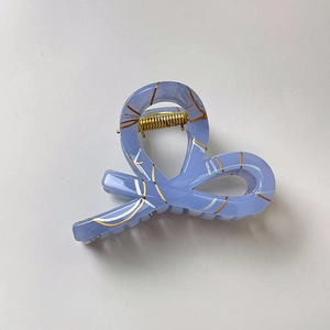 Detail view of lace bow hair claw clip in lavender with metallic gold accents