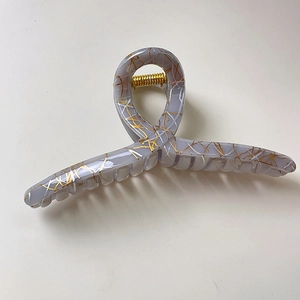 Detail of lavender acetate hair claw clip featuring golden silk textures and durable spring