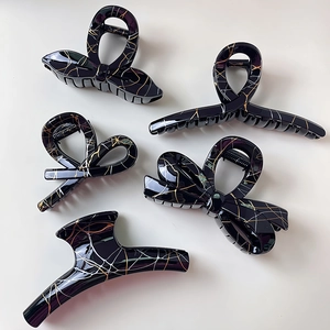 Set of five black and gold marble pattern hair claws with bow and minimalist designs