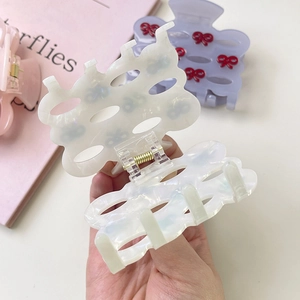 Detailed close-up of sweet acetate hollow bow hair claw clip with durable metal spring