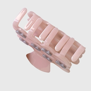 Detail view of pink acetic acid hair claw with flower decor and sturdy teeth grip