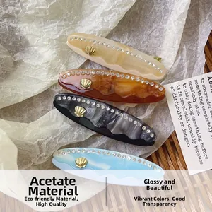 Set di quattro fermagli in acetato marmorizzato con strass di cristallo e decori a conchiglia