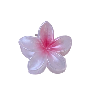Close-up of pink and white gradient resin plumeria flower hair claw clip on white background