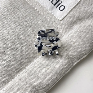 Detail of mini marble hair claw clip with elegant white pearls and black ink pattern