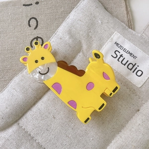 Detail view of a cute giraffe hair claw clip made of glossy acetate with purple spots