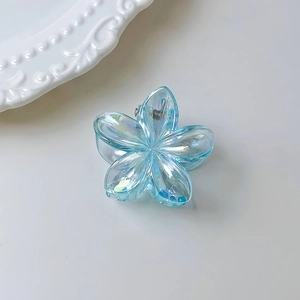 Dettaglio macro della molletta per capelli a fiore blu traslucido con finitura perlata