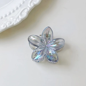 Dettaglio macro di un fermaglio per capelli a fiore con finitura sfumata iridescente