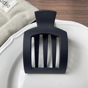 Detail of matte black hollow hair clip showing its elegant rectangular three-tooth design