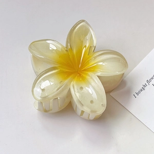 Detailopname van een 8 cm haarklem in de vorm van een gradiënt frangipani-bloem
