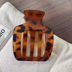 Vue détaillée d'une pince à cheveux carrée en résine ambre avec motif écaille de tortue