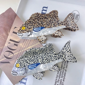 Pinze per capelli in acetato a forma di pesce con motivi leopardati e floreali chiari