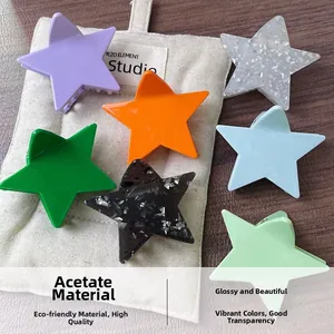 Set of 7 acetate star-shaped hair claws in vibrant colors on a minimalist canvas bag