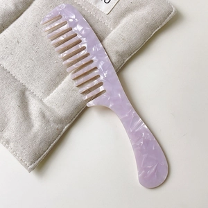 Detail of lavender marble acetate wide-tooth comb showing delicate semi-transparent texture